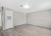 Thumbnail 4 of 39 - the living room of an empty apartment with wood flooring at Emerald Greens, Norman Oklahoma