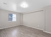 Thumbnail 30 of 39 - an empty living room with wood flooring and a window at Emerald Greens, Norman, OK