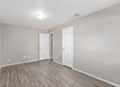 Thumbnail 29 of 39 - an empty living room with wood flooring and white walls at Emerald Greens, Norman, OK 73072