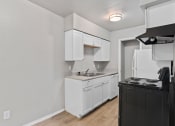 Thumbnail 39 of 39 - an empty kitchen with white cabinets and a stove and refrigerator at Emerald Greens, Norman Oklahoma