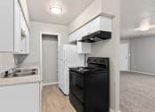 Thumbnail 35 of 39 - an empty kitchen with white cabinets and a black stove and refrigerator at Emerald Greens, Oklahoma, 73072