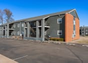 Thumbnail 19 of 39 - the exterior of a apartment building with a parking lot at Emerald Greens, Norman