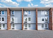 Thumbnail 8 of 17 - A row of apartment buildings with garage doors.