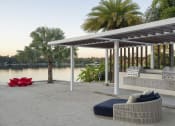 Thumbnail 10 of 17 - a patio with a couch and a table next to a river at Lakeside Villas, Orlando, FL