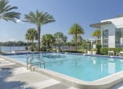 Thumbnail 7 of 17 - a swimming pool in front of a building with palm trees at Lakeside Villas, Orlando, FL 32817