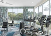 Thumbnail 5 of 17 - a gym with a pool and workout equipment in front of windows at Lakeside Villas, Orlando, 32817