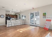 Thumbnail 35 of 51 - a common room with a kitchen and a door to the lobby of a building at Lake Lofts at Deerwood, Jacksonville, Florida