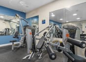 Thumbnail 30 of 51 - a gym with exercise equipment and mirrors in a building at Lake Lofts at Deerwood, Jacksonville, FL