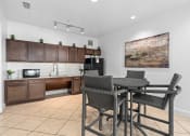 Thumbnail 29 of 51 - a kitchen and dining area with a table and chairs at Lake Lofts at Deerwood, Jacksonville, FL, 32216