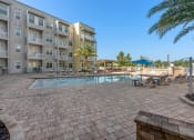 Thumbnail 12 of 51 - a swimming pool with an apartment building in the background at Lake Lofts at Deerwood, Jacksonville, 32216