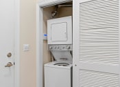 Thumbnail 51 of 51 - the laundry room has a washer and dryer and a white door at Lake Lofts at Deerwood, Jacksonville