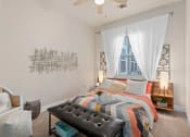 Thumbnail 36 of 51 - a bedroom with a bed and a window and a ceiling fan at Lake Lofts at Deerwood, Jacksonville, FL, 32216