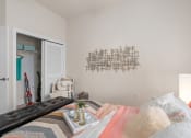 Thumbnail 50 of 51 - a bedroom with a bed and a white door to a closet at Lake Lofts at Deerwood, Jacksonville, Florida