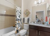 Thumbnail 43 of 51 - a bathroom with a shower toilet and sink and a mirror at Lake Lofts at Deerwood, Jacksonville, FL, 32216