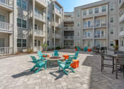 Thumbnail 14 of 51 - an outdoor patio with chairs and tables in an apartment building at Lake Lofts at Deerwood, Jacksonville, FL, 32216