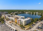 Thumbnail 9 of 51 - an aerial view of a building next to a lake at Lake Lofts at Deerwood, Jacksonville, FL, 32216