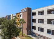 Thumbnail 1 of 51 - a building with the ace properties logo on the side of it at Lake Lofts at Deerwood, Jacksonville, FL