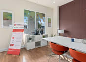 Thumbnail 27 of 51 - a conference room with a table and chairs and a sign at Lake Lofts at Deerwood, Jacksonville, FL