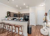 Thumbnail 47 of 51 - a kitchen with a bar and a counter with stools at Lake Lofts at Deerwood, Jacksonville, FL