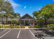 Thumbnail 21 of 21 - the front of a building with a parking lot and trees at Oak Reserve at Winter Park, Winter Park