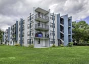 Thumbnail 31 of 54 - a grey apartment building with a green lawn in front of it  at Club at Emerald Waters, Florida