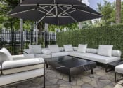 Thumbnail 24 of 54 - an outdoor patio with white couches and a black coffee table  at Club at Emerald Waters, Hollywood, 33021