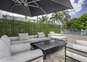 Thumbnail 28 of 54 - a patio with couches and a coffee table and a pool in the background  at Club at Emerald Waters, Hollywood, FL, 33021