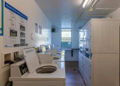 Thumbnail 43 of 54 - a laundry room with a row of washers and dryers  at Club at Emerald Waters, Hollywood, FL, 33021