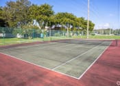 Thumbnail 42 of 54 - a tennis court with a fenced in area and trees in the background  at Club at Emerald Waters, Florida, 33021