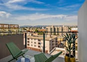 Thumbnail 12 of 27 - Two green chairs are on a balcony overlooking a cityscape at WM by CLG, Los Angeles California  