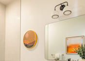 Thumbnail 22 of 27 - A bathroom with a white toilet, a white sink, a mirror, and a painting on the wall at WM by CLG, California, 90232