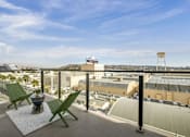 Thumbnail 8 of 27 - A balcony with two green chairs and a table at WM by CLG, Los Angeles, CA 90232  