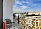 Thumbnail 11 of 27 - A balcony with a chair and table overlooks a city street at WM by CLG, Los Angeles, 90232  