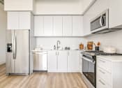 Thumbnail 21 of 27 - A modern kitchen with white cabinets and stainless steel appliances at WM by CLG, Los Angeles, CA 90232  