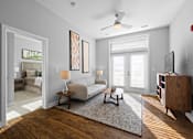 Thumbnail 2 of 34 - A spacious living room with hardwood-style flooring, double doors to a patio, and a ceiling fan near an doorway to a bedroom.