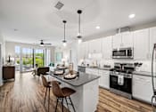 Thumbnail 1 of 39 - A modern kitchen with white cabinets and a wooden floor.