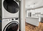 Thumbnail 33 of 34 - A white washing machine in a laundry room.