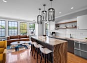 Thumbnail 32 of 39 - A modern kitchen with a wooden island and white cabinets.