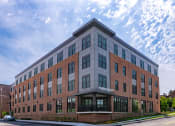 Thumbnail 1 of 17 - a large brick building with a street in front of it