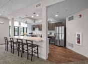 Thumbnail 12 of 17 - a kitchen with stainless steel appliances and a large island with chairs