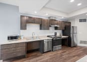 Thumbnail 14 of 17 - a kitchen with stainless steel appliances and wooden cabinets