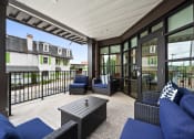 Thumbnail 17 of 17 - a covered patio with blue furniture and glass doors