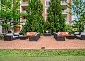 Thumbnail 36 of 59 - A patio with a table and chairs is surrounded by trees and apartment buildings.