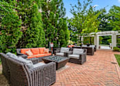 Thumbnail 14 of 59 - A patio with a table and chairs surrounded by greenery.