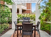 Thumbnail 17 of 59 - A patio with a table and chairs and a laptop on it.