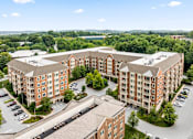 Thumbnail 33 of 59 - A large apartment complex with a parking lot in front.