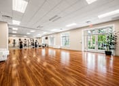 Thumbnail 51 of 59 - A spacious room with wooden floors and white furniture.