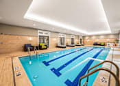 Thumbnail 19 of 59 - A large indoor swimming pool with blue lanes and a wooden floor.