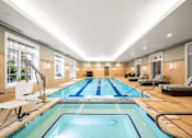 Thumbnail 50 of 59 - A large indoor swimming pool with a diving board and lane markers.