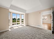 Thumbnail 29 of 59 - A spacious room with a carpeted floor and a view of the outside through the windows.